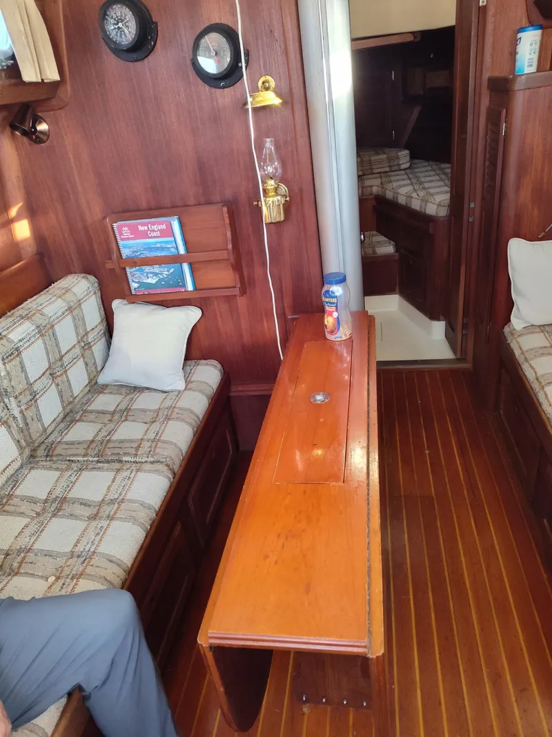 Slide: The Image of Interior of 1982 Bristol 35.5 sailboat with wooden furnishings and plaid seating. - 12