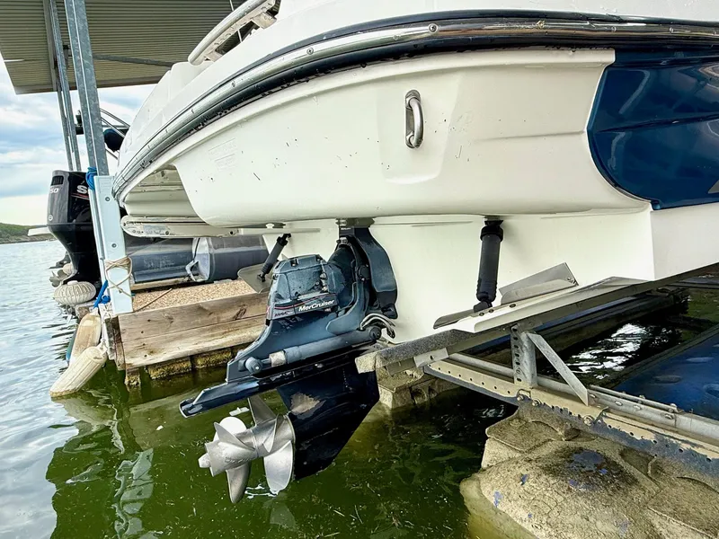 Slide: The Image of 2013 Sea Ray 250 SLX boat on lift, showing MerCruiser outdrive and propeller. - 10