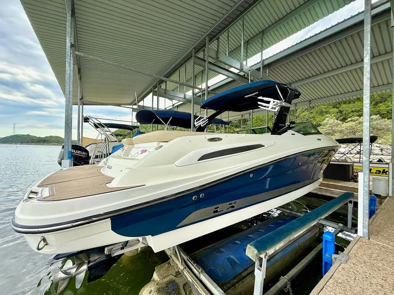 Slide: The Image of 2013 Sea Ray 250 SLX boat docked under a covered marina. - 11