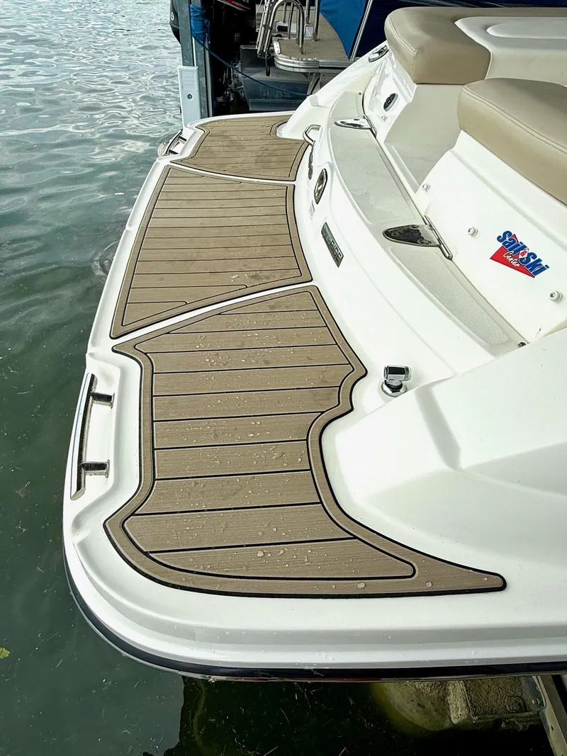 Slide: The Image of 2013 Sea Ray 250 SLX boat with teak-style swim platform by the water. - 18