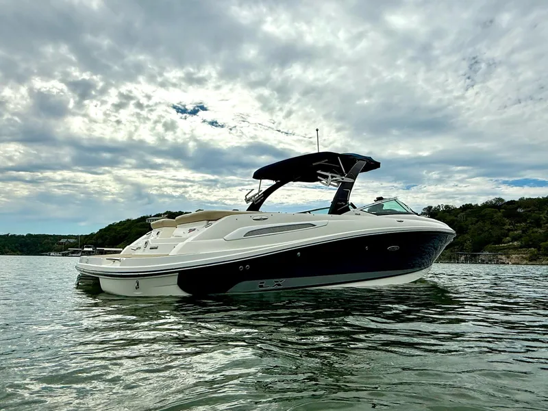 Slide: The Image of 2013 Sea Ray 250 SLX boat on calm water under cloudy sky. - 2