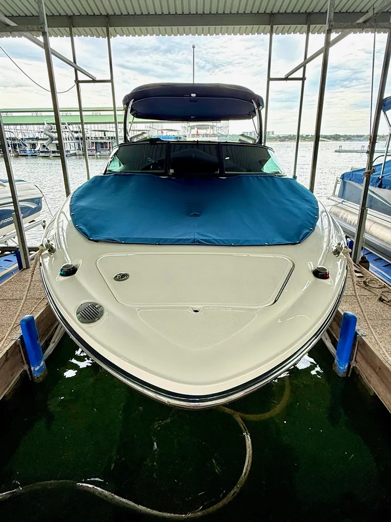 Slide: The Image of 2013 Sea Ray 250 SLX boat docked with blue cover, under a canopy. - 20
