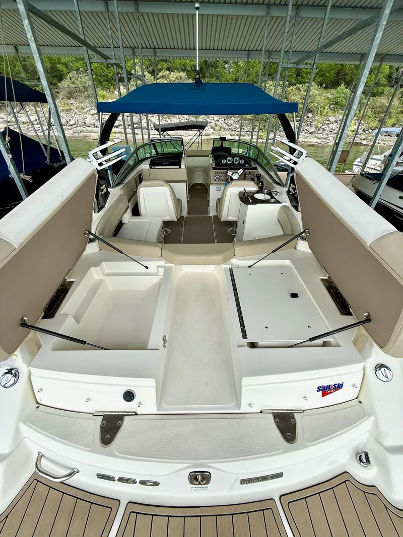 Slide: The Image of 2013 Sea Ray 250 SLX boat interior with open storage compartments and seating under a canopy. - 24