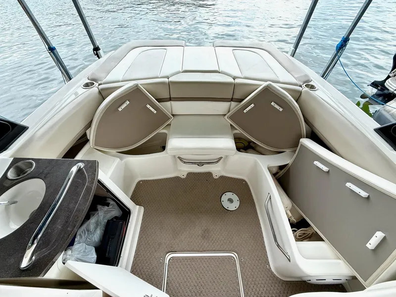Slide: The Image of 2013 Sea Ray 250 SLX boat interior with open storage compartments and seating. - 27