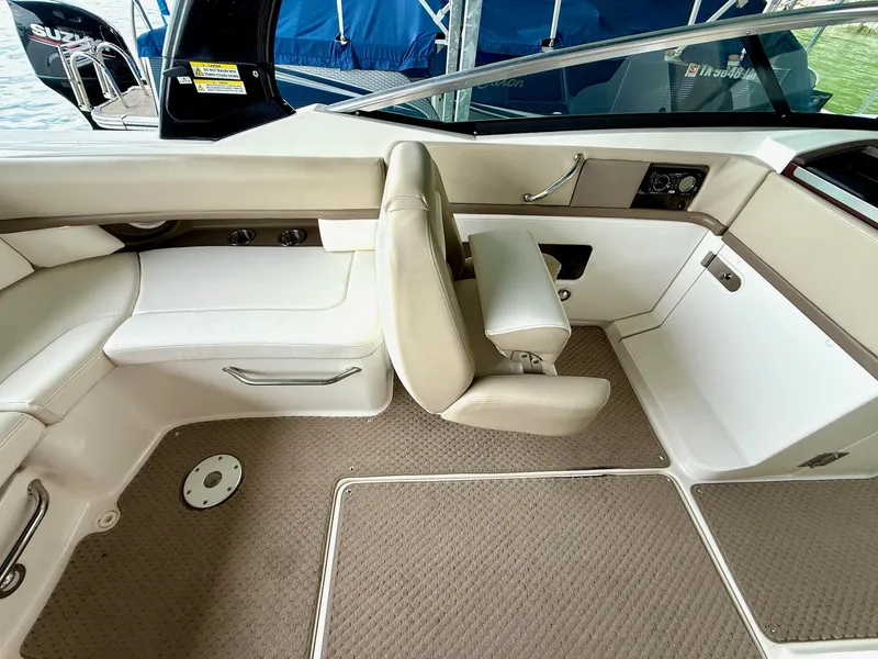 Slide: The Image of Interior of a 2013 Sea Ray 250 SLX boat with beige seating and carpeted flooring. - 30