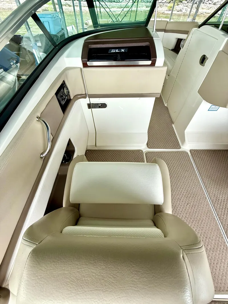 Slide: The Image of Interior of a 2013 Sea Ray 250 SLX boat, featuring beige seating and dashboard. - 33