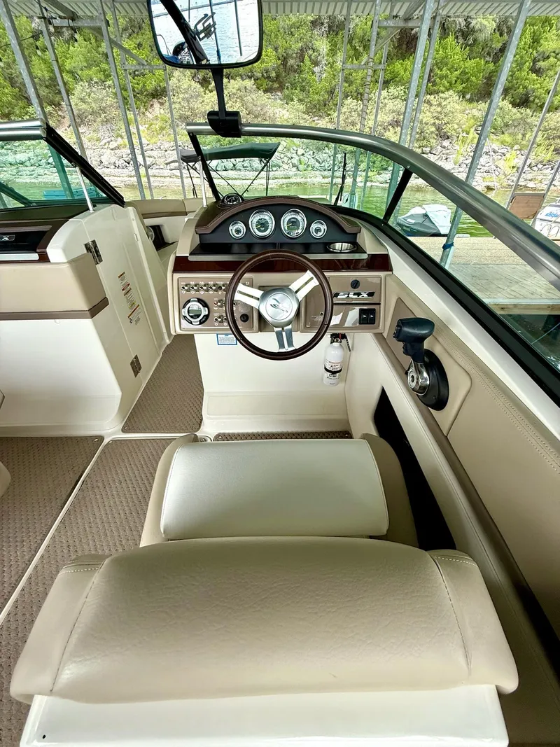 Slide: The Image of 2013 Sea Ray 250 SLX boat interior with steering wheel and dashboard controls. - 34
