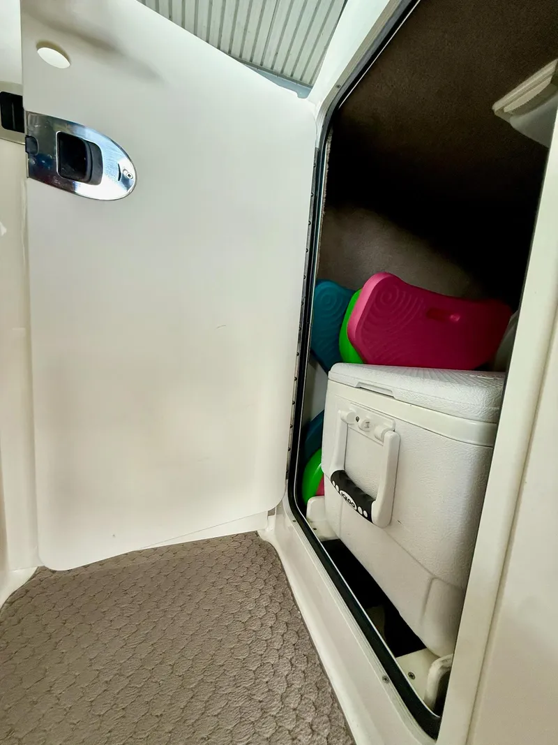 Slide: The Image of Storage compartment in a 2013 Sea Ray 250 SLX boat with colorful mats and cooler. - 36