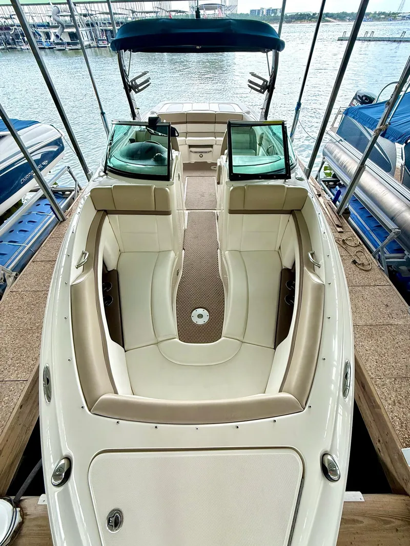 Slide: The Image of 2013 Sea Ray 250 SLX boat interior with beige seating, docked by the water. - 39