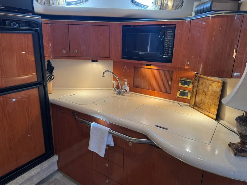 Slide: The Image of Luxurious kitchen area in a 2001 Sea Ray 380 Sundancer yacht with wood cabinetry. - 25