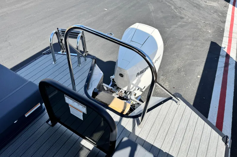 Slide: The Image of 2025 Manitou Explore 24 Navigator boat with Mercury outboard motor, rear deck view. - 18