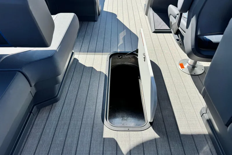 Slide: The Image of Open storage compartment on 2025 Manitou Explore 24 Navigator boat deck. - 23