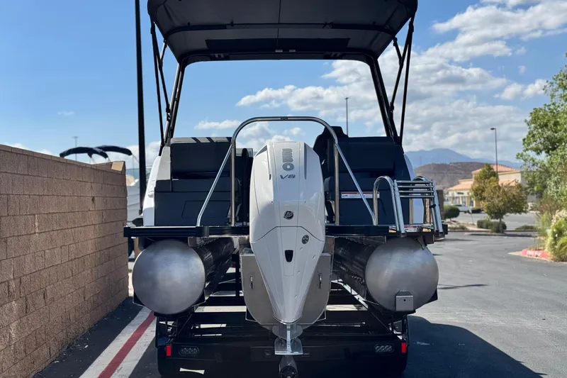 Slide: The Image of 2025 Manitou Explore 24 Navigator pontoon boat with V8 engine, parked outdoors. - 5