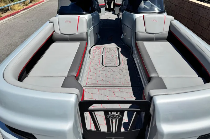 Slide: The Image of 2023 Manitou 25 XT RFXW boat interior with sleek gray seating and red accents. - 11