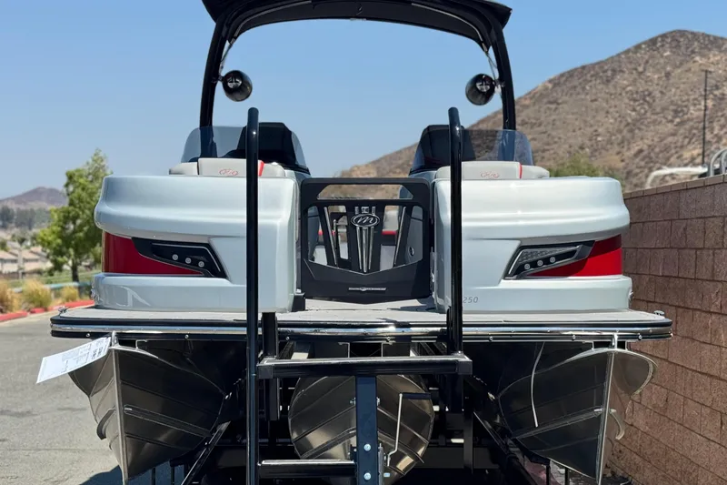 Slide: The Image of 2023 Manitou 25 XT RFXW pontoon boat, rear view, parked outdoors. - 2