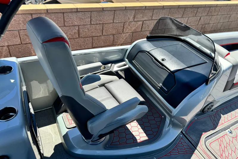 Slide: The Image of 2023 Manitou 25 XT RFXW boat interior with captain's chair and dashboard. - 22
