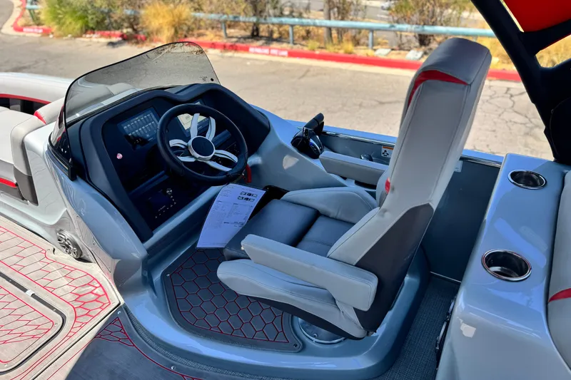 Slide: The Image of 2023 Manitou 25 XT RFXW boat interior with steering wheel and captain's chair. - 23