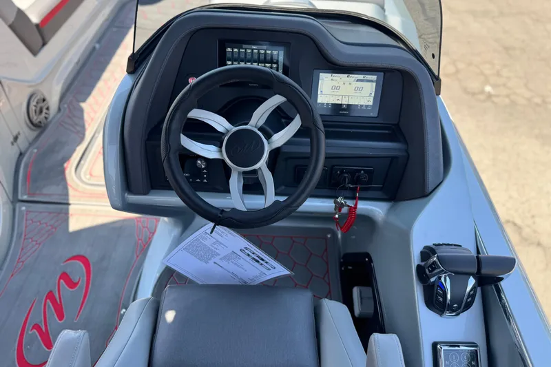 Slide: The Image of 2023 Manitou 25 XT RFXW boat dashboard with steering wheel and digital display. - 24