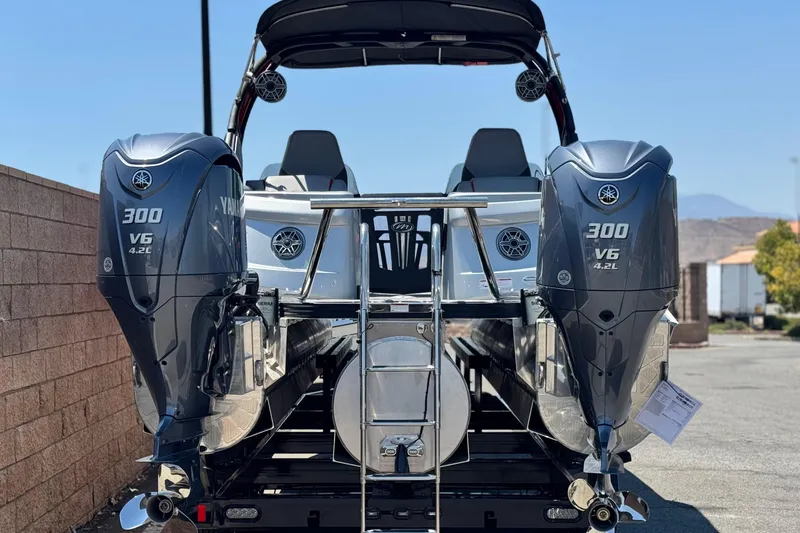 Slide: The Image of 2023 Manitou 25 XT RFXW boat with dual Yamaha 300 V6 engines, rear view. - 5