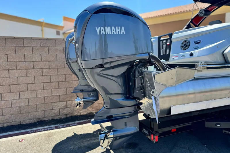 Slide: The Image of 2023 Manitou 25 XT RFXW boat with Yamaha outboard motors, parked outdoors. - 7