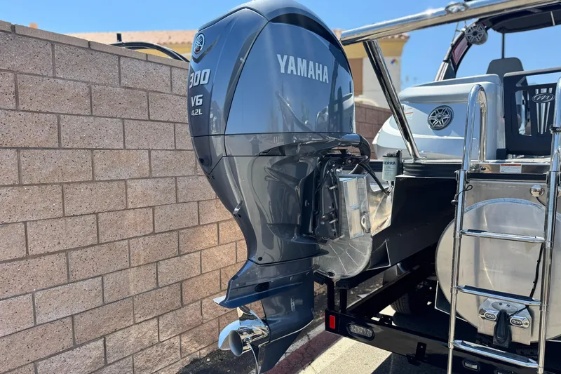 Slide: The Image of 2023 Manitou 25 XT RFXW with Yamaha V6 300 outboard engine, parked outdoors. - 8