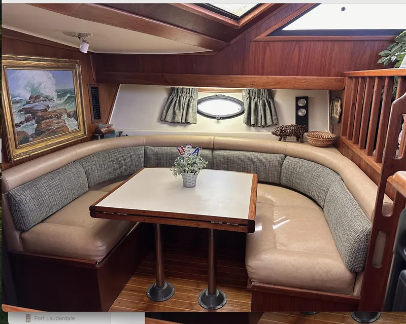 Slide: The Image of 1987 Californian 48 Cockpit Motor Yacht interior with cozy dining area and nautical decor. - 11