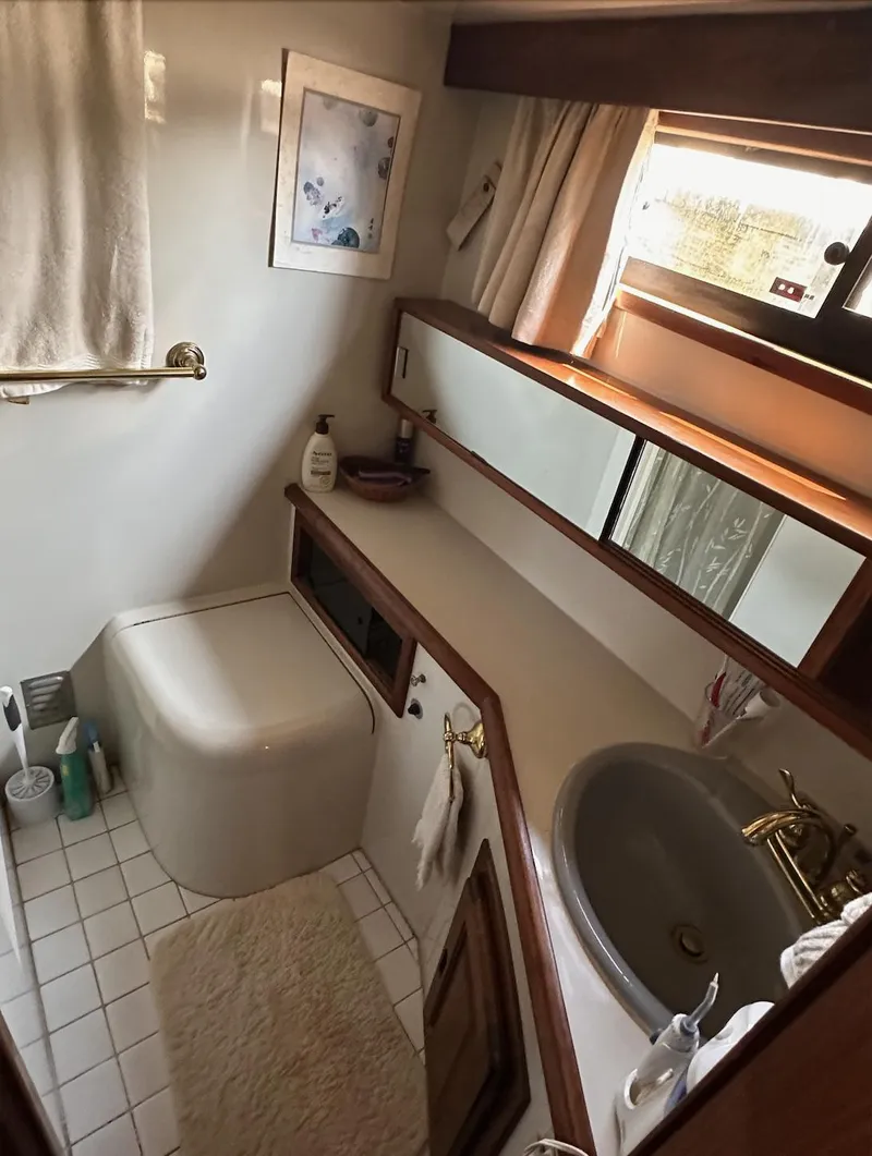 Slide: The Image of Bathroom interior of 1987 Californian 48 Cockpit Motor Yacht, featuring sink and toilet. - 16