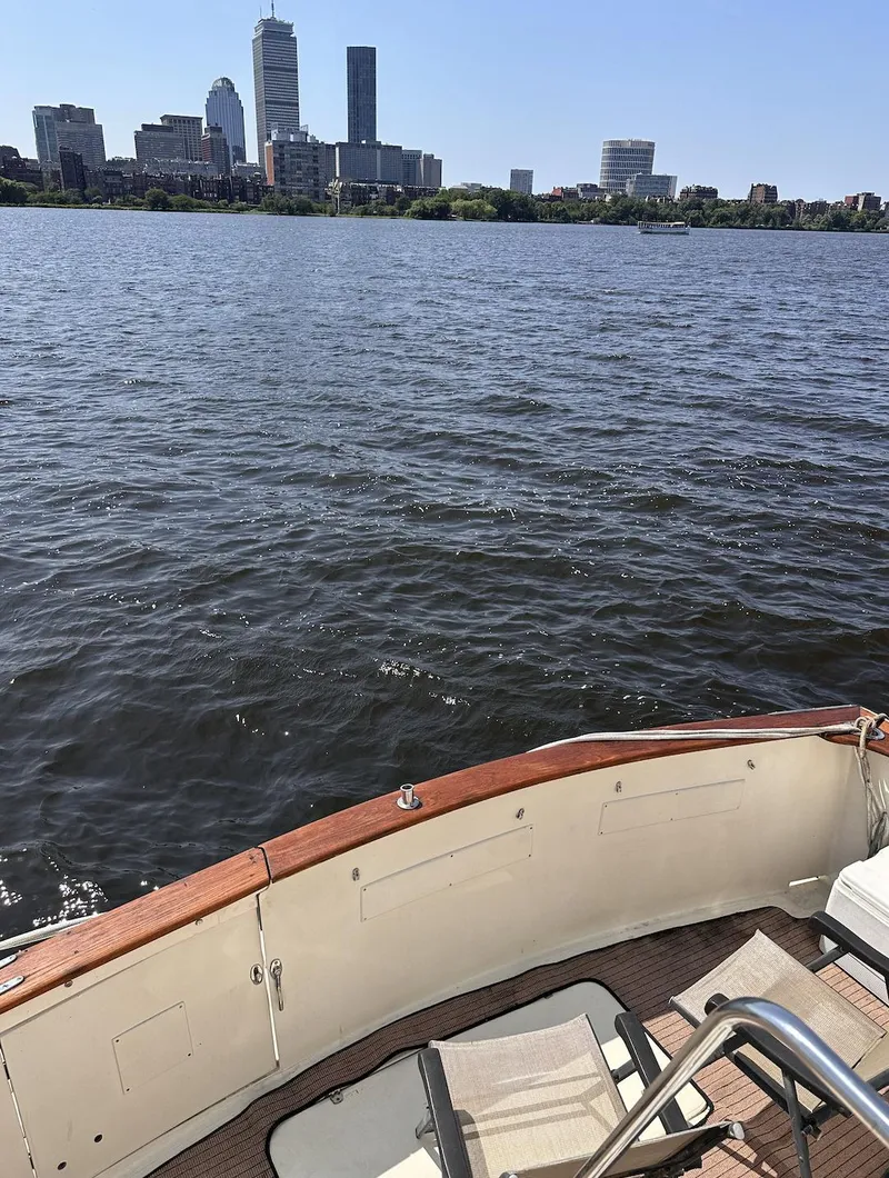 Slide: The Image of 1987 Californian 48 Cockpit Motor Yacht on water with city skyline in background. - 20
