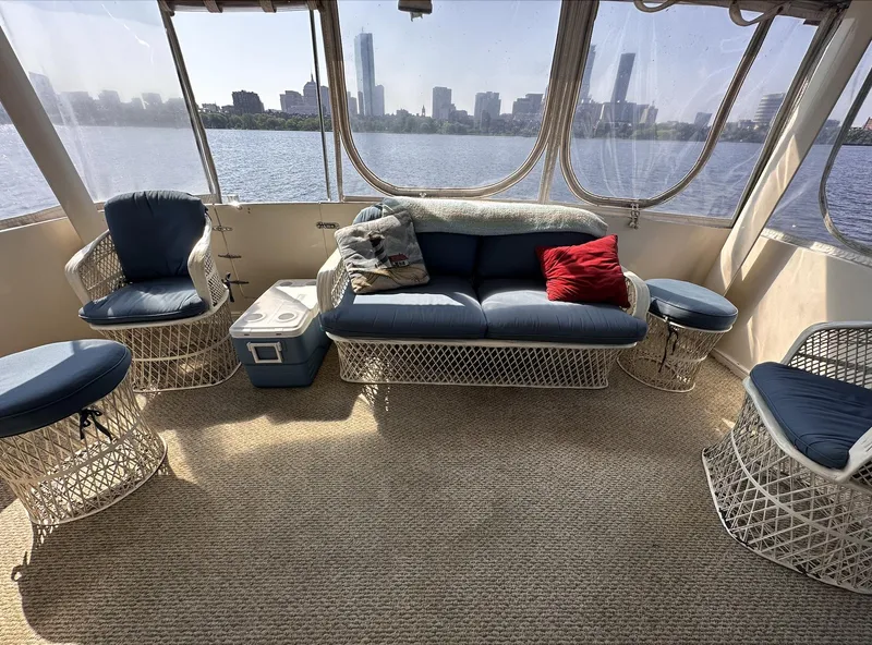 Slide: The Image of 1987 Californian 48 Cockpit Motor Yacht interior with wicker furniture and city skyline view. - 24