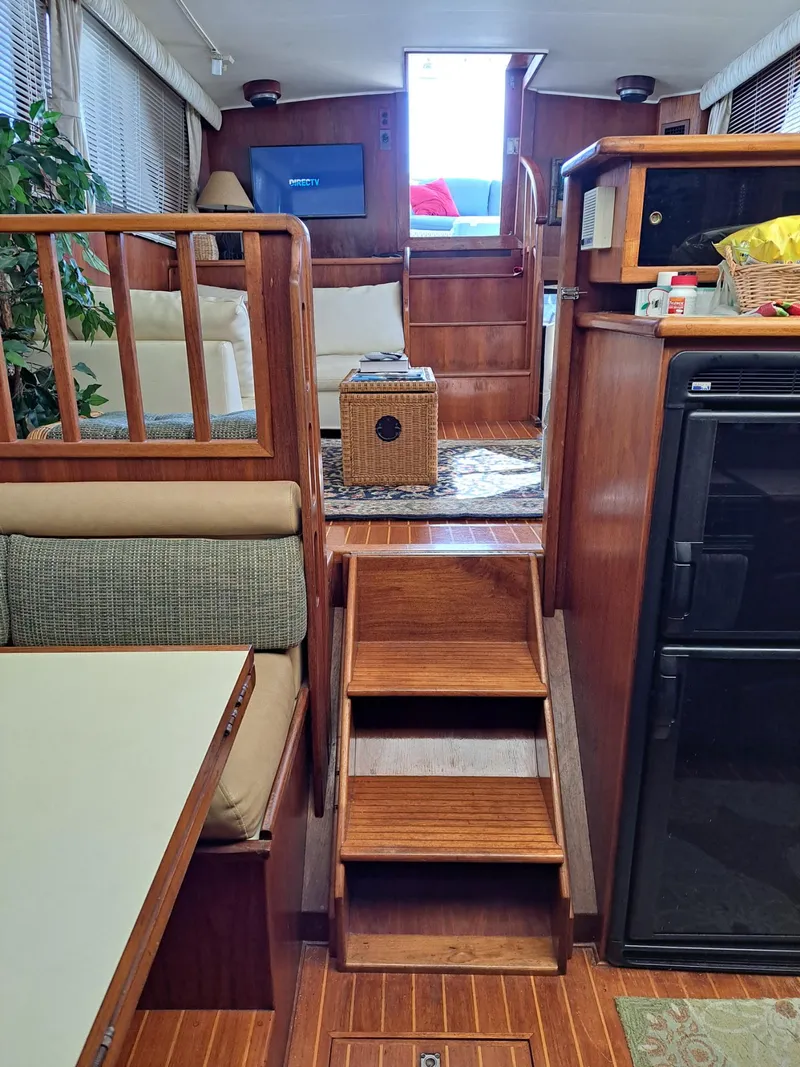 Slide: The Image of Interior of 1987 Californian 48 Cockpit Motor Yacht with wooden stairs and cozy seating area. - 5