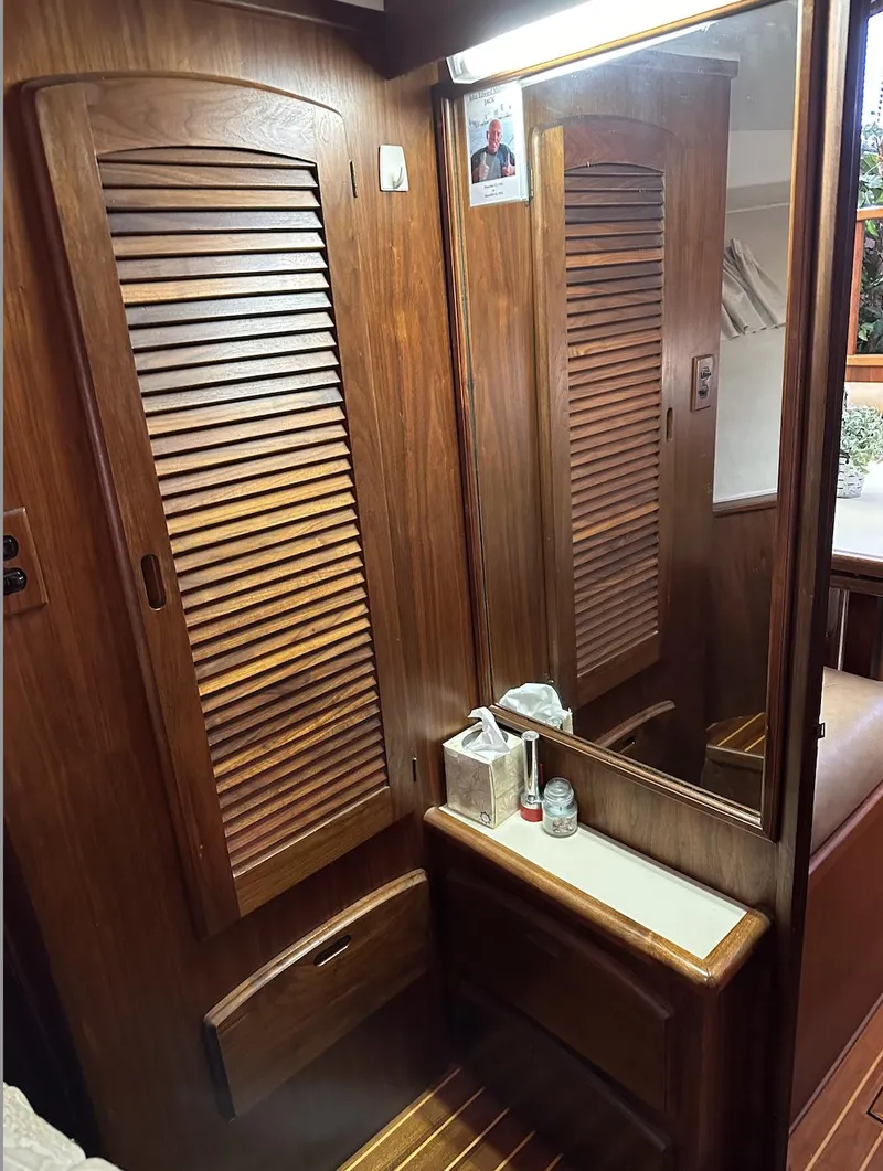 Slide: The Image of 1987 Californian 48 Cockpit Motor Yacht interior with wooden cabinetry and mirror. - 9
