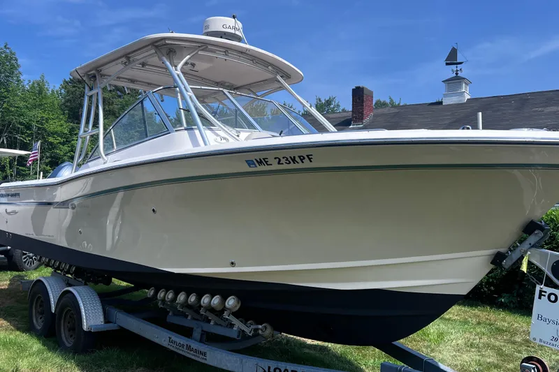 Slide: The Image of 2012 Grady-White Freedom 275 boat on trailer, parked outdoors under clear blue sky. - 18