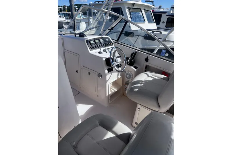 Slide: The Image of 2012 Grady-White Freedom 275 boat interior with steering wheel and control panel. - 23