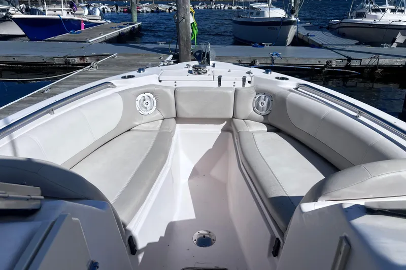 Slide: The Image of 2012 Grady-White Freedom 275 boat interior with cushioned seating at marina. - 26
