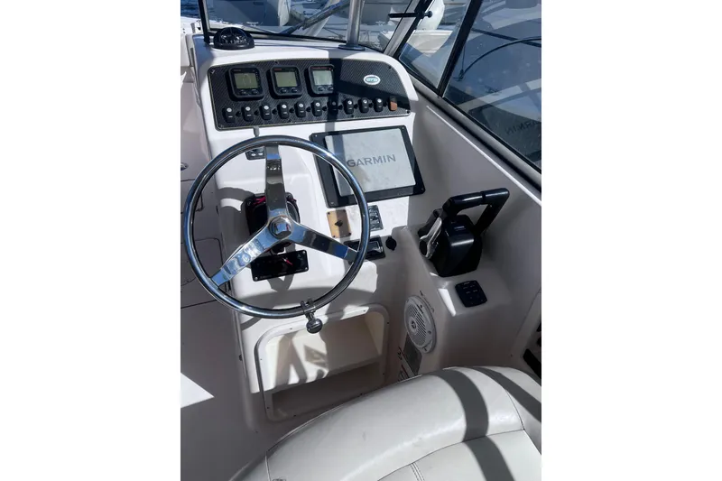 Slide: The Image of 2012 Grady-White Freedom 275 boat dashboard with Garmin navigation system and steering wheel. - 27