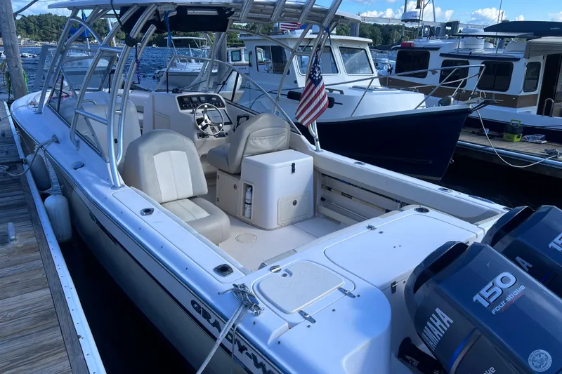 Slide: The Image of 2012 Grady-White Freedom 275 boat docked, featuring dual Yamaha engines and American flag. - 31