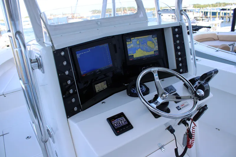Slide: The Image of 1998 Venture 34 Open boat helm with navigation screens and steering wheel. - 15