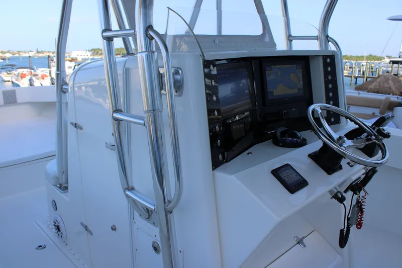 Slide: The Image of 1998 Venture 34 Open boat helm with navigation screens and steering wheel. - 19