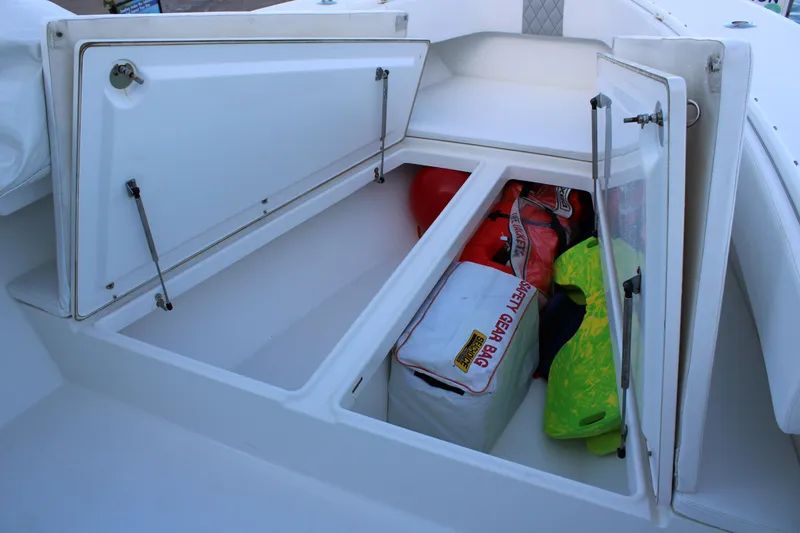 Slide: The Image of Open storage compartments on a 1998 Venture 34 Open boat, containing safety gear and equipment. - 23