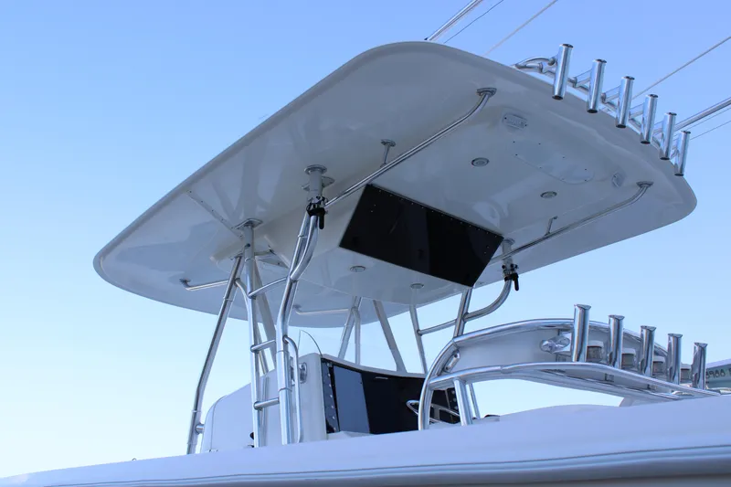 Slide: The Image of Venture 34 Open 1998 boat with sleek T-top and rod holders against clear sky. - 34