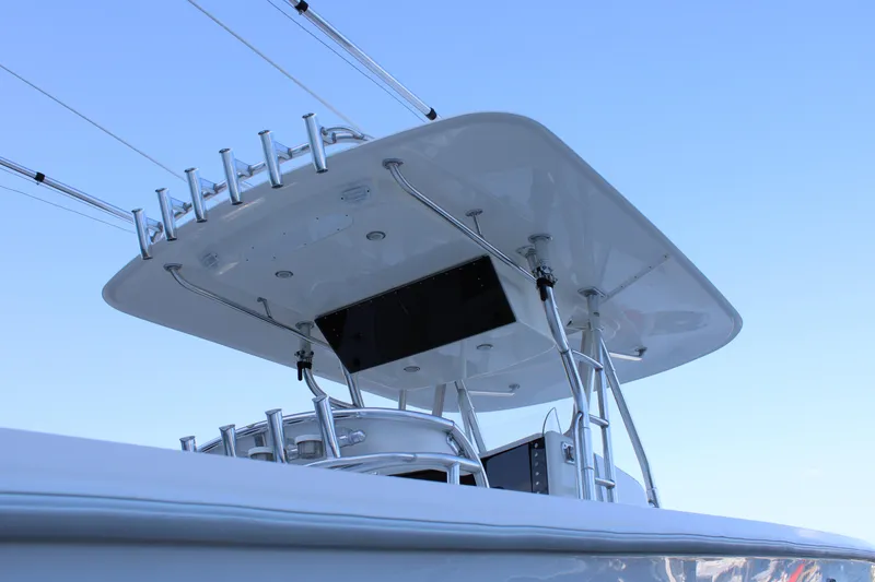 Slide: The Image of 1998 Venture 34 Open boat with T-top and rod holders against clear sky. - 35