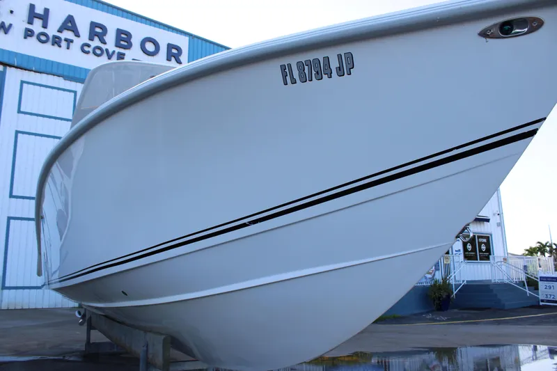 Slide: The Image of 1998 Venture 34 Open boat at marina, side view with registration number visible. - 4