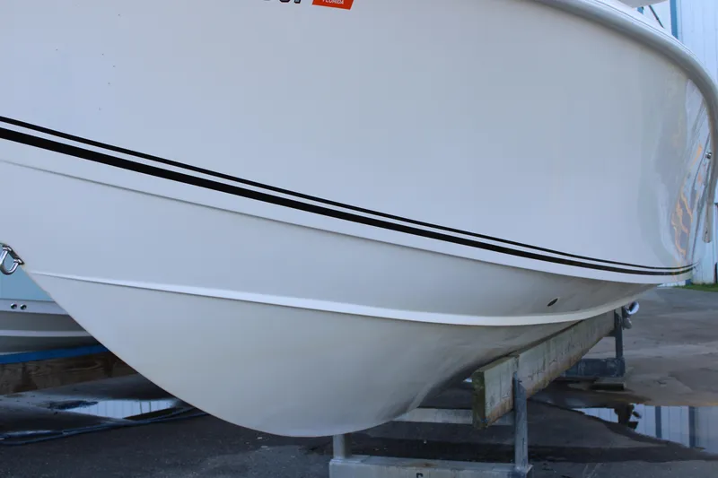 Slide: The Image of 1998 Venture 34 Open boat hull on trailer, white with black stripe. - 5