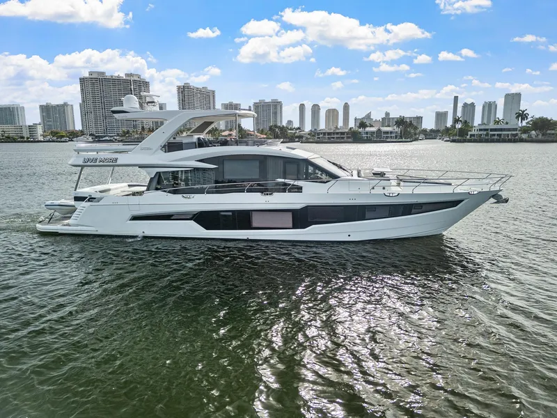 Slide: The Image of 2021 Galeon 680 Fly yacht cruising on water with city skyline in background. - 33
