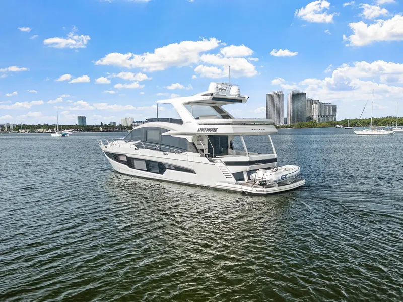 Slide: The Image of 2021 Galeon 680 Fly yacht cruising on a sunny day with city skyline in background. - 35
