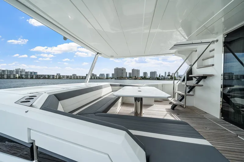 Slide: The Image of Luxurious 2021 Galeon 680 Fly yacht deck with seating, table, and city skyline view. - 43