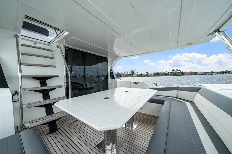 Slide: The Image of Luxurious 2021 Galeon 680 Fly yacht deck with seating and table, overlooking serene waters. - 47