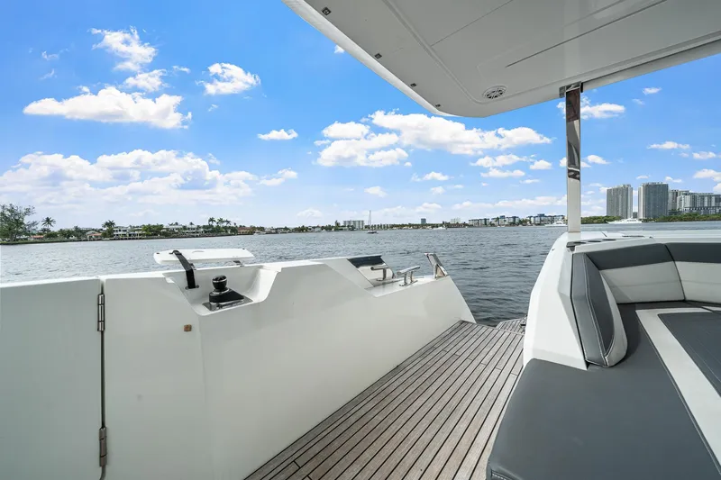 Slide: The Image of Luxury deck view of 2021 Galeon 680 Fly yacht, overlooking serene waterfront and cityscape. - 48