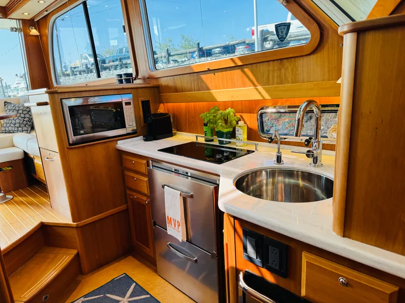 Slide: The Image of Luxurious 2018 Sabre 42 Salon Express yacht kitchen with modern appliances and elegant wood finish. - 10