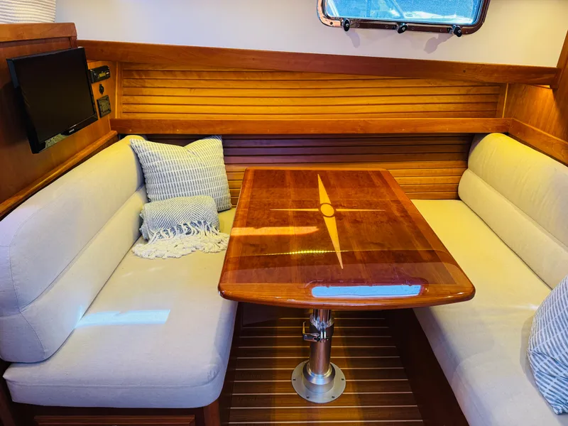 Slide: The Image of Interior of 2018 Sabre 42 Salon Express with wooden table and cushioned seating. - 14
